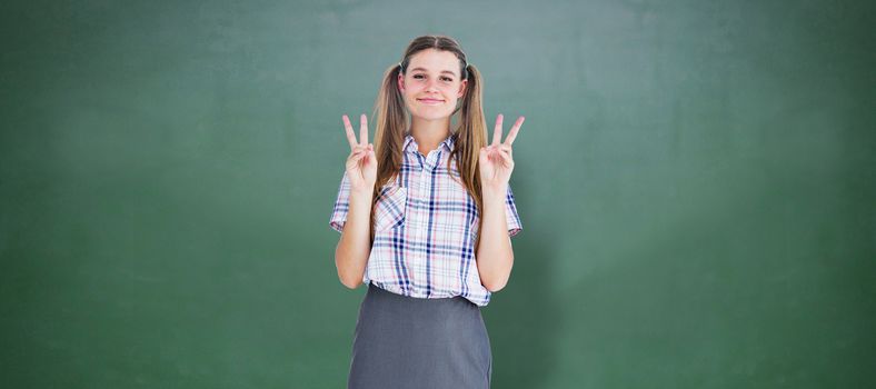 Geeky hipster smiling at camera  against green chalkboard