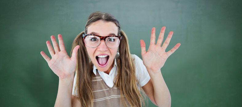 Female geeky hipster smiling at camera  against green chalkboard