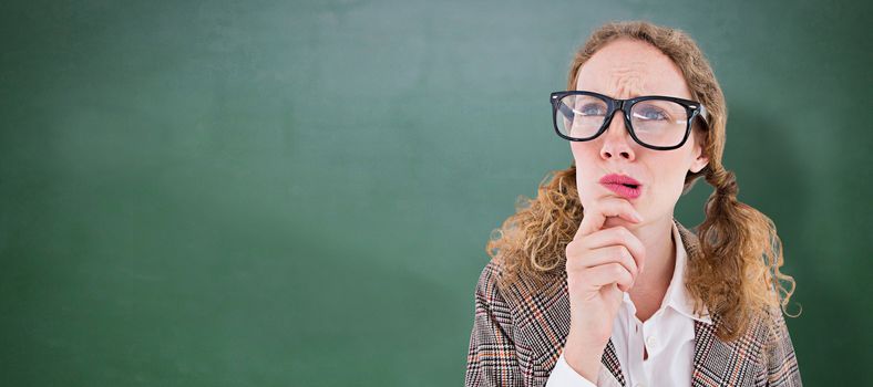 Geeky hipster woman thinking with hand on chin against green chalkboard