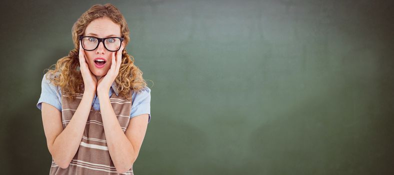 Geeky hipster woman putting her fingers in her ears against green chalkboard