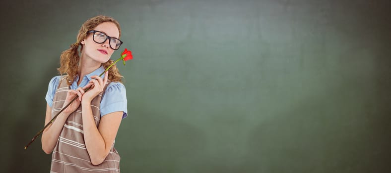 Geeky hipster woman holding rose  against green chalkboard