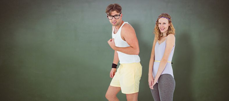 Geeky hipster couple posing in sportswear against green chalkboard