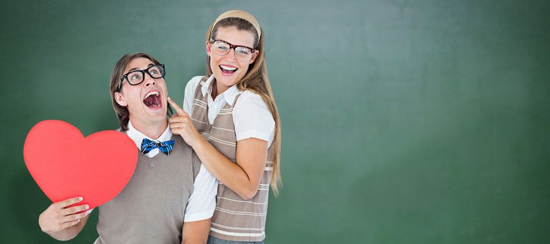 Excited geeky hipster and his girlfriend  against green chalkboard