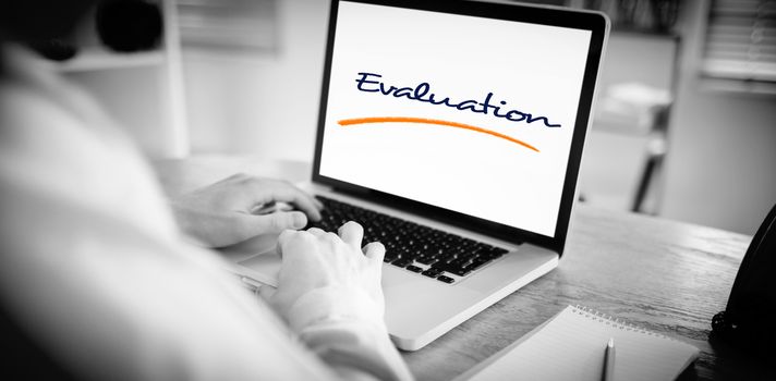 The word evaluation against businessman working on his laptop