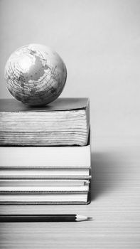 book and earth ball with black pencil on wood background black and white color tone style