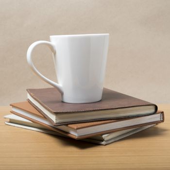 stack of book with coffee mug on wood background