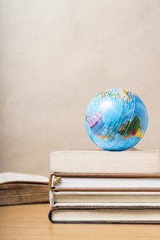 book and earth ball on wood background