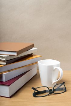 stack of book with coffee mug on wood background