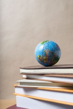 stack of book and earth ball on wood background