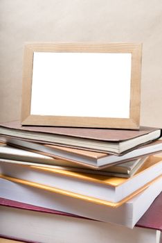 stack of book and photo frame on wood background