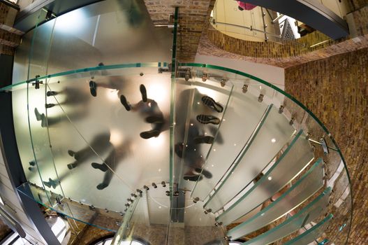 Underneath view of people feet walking on a circular staircase.