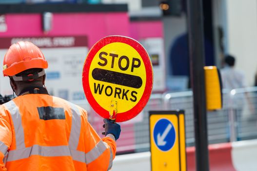 Roadworks signal with worker standing.
