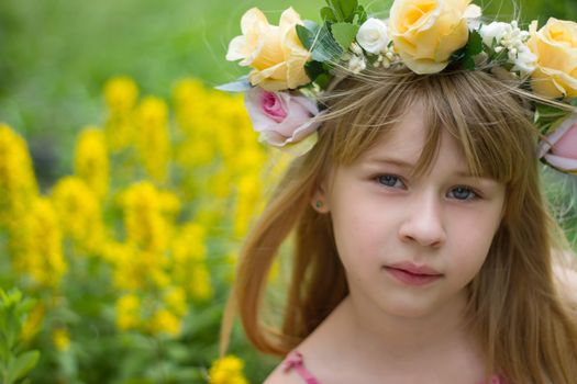 Girl 6 years old in a wreath close-up against a landscape