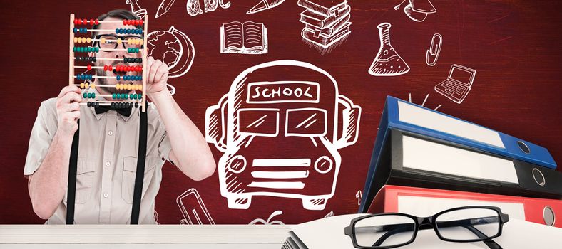 Geeky hipster holding an abacus against desk