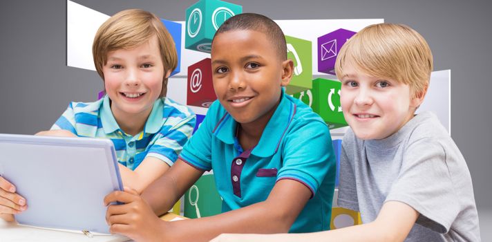 Cute pupils using tablet computer in library against abstract room