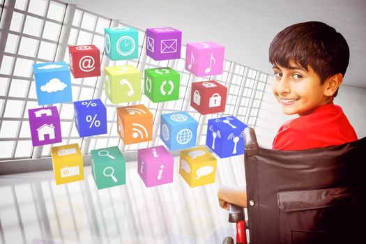 Boy sitting in wheelchair in school against abstract room