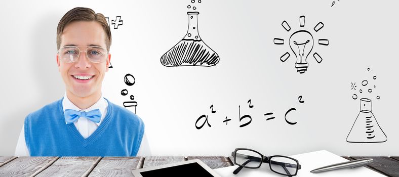 Geeky young hipster smiling at camera against desk