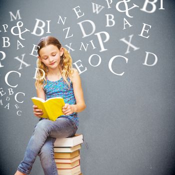 Cute little girl reading book in library against grey background