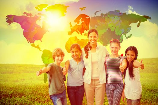 Cute pupils and teacher smiling at camera in computer class  against green field under blue sky