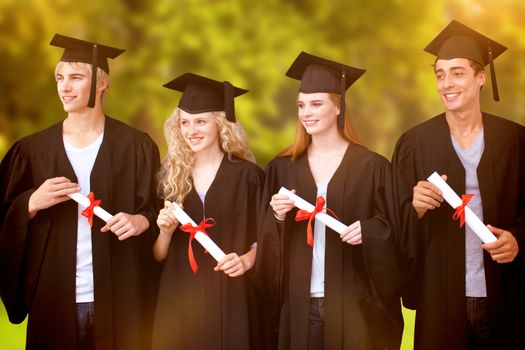 Group of people celebrating after Graduation against trees and meadow