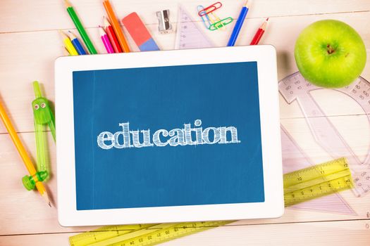 The word education and students desk with tablet pc against blackboard with copy space on wooden board