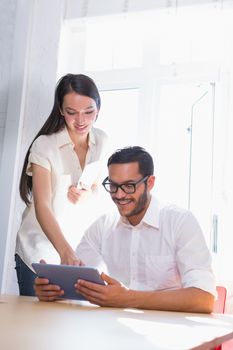 Two casual business people using digital tablet