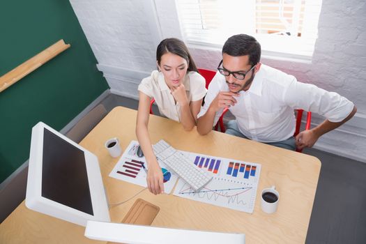 High angle view of two casual young colleagues in meeting at office