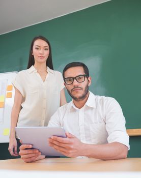 Two casual business people using digital tablet