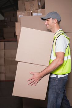 Side view of worker carrying boxes in the warehouse