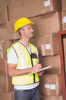 Warehouse worker with clipboard in warehouse