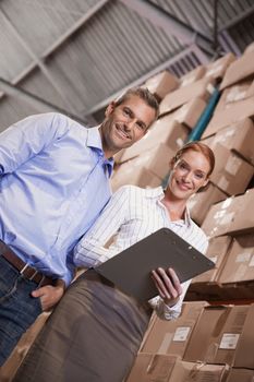 Manager and colleague working together in warehouse