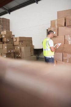 Warehouse worker with clipboard in warehouse