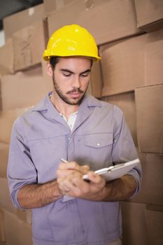 Warehouse worker with clipboard in warehouse