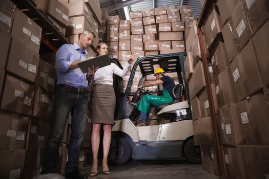 Manager and colleague working together in warehouse