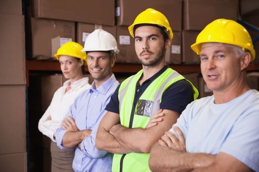Portrait of smiling confident team standing in warehouse