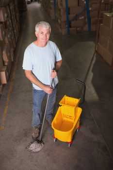 Portrait of man moping warehouse floor