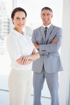 Smiling business people with folded arms at work