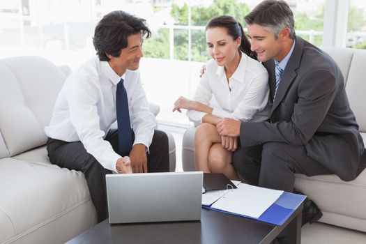 Business team looking at a laptop in an office