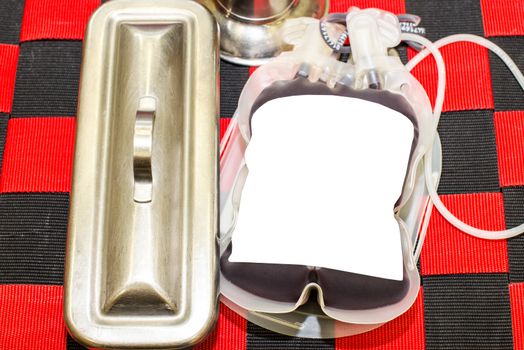 Close up bag of blood and plasma and rubber tube isolated on Red background