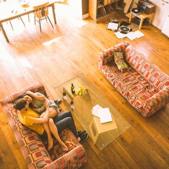 Young couple cuddling on the couch at home in the living room