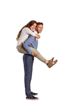 Portrait of smiling young man carrying woman over white background