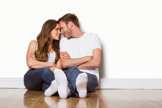 Full length of romantic young couple sitting on floor