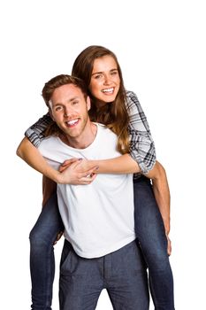 Portrait of smiling young man carrying woman over white background