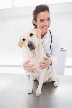 Happy veterinarian examining a cute dog in medical office