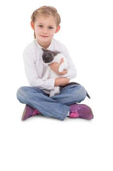 Little girl sitting with cat in her arms on white background