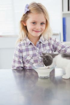 Happy owner petting her cat drinking milk in medical office