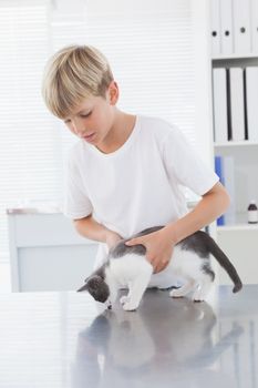 Smiling owner holding his cat in medical office