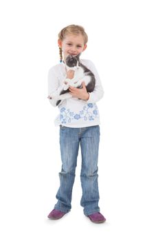 Smiling little girl with her cute kitten on white background