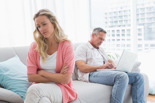 Unhappy couple are stern and having troubles at home in the living room