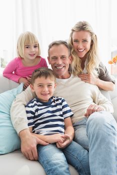 Portrait of a cheerful family on the couche at home in the living room